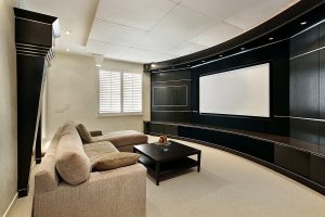 A media room setup with a home theater system featuring high-end AV solutions and couch seating.