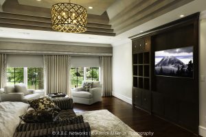 Elegant bedroom with motorized blackout shades and a TV custom integrated into cabinetry.